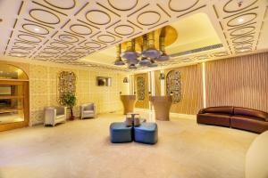 a lobby with two blue ottomans in a room at Jagadish Hotels Sankey Road in Bangalore