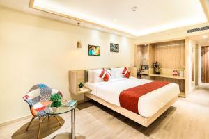 a bedroom with a bed and a table and a chair at Jagadish Hotels Sankey Road in Bangalore