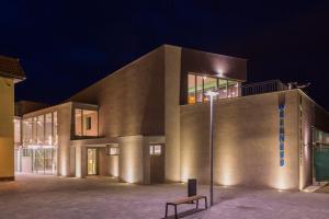 a building with a bench in front of it at night at Wellness Hotel Thermal in Štúrovo