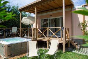 ein Poolhaus mit einer Terrasse und einem Whirlpool in der Unterkunft Camping Del Sole Village in Iseo