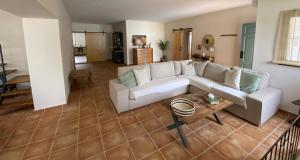 a living room with a white couch and a table at Chalet con encanto cerca de Sevilla in Alcalá de Guadaira