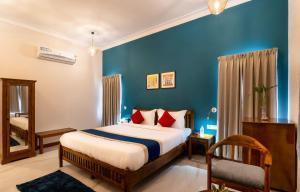 1 dormitorio con cama y pared azul en Dheergarh Palace, en Udaipur