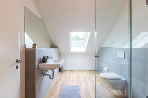 ein weißes Bad mit einem Waschbecken und einem WC in der Unterkunft Glück Auf Appartements Kaiserstraße Mülheim in Mülheim an der Ruhr