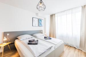 a white bedroom with a large bed and a window at Glück Auf Appartements Kaiserstraße Mülheim in Mülheim an der Ruhr