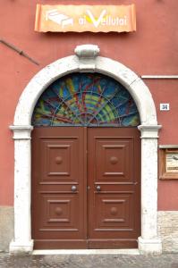 una puerta marrón con una vidriera encima en Ai Vellutai, en Ala