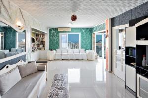 uma sala de estar com mobiliário branco e paredes verdes em Magnificent Views Suite em Hersonissos