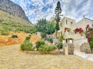 uma casa grande com flores ao lado de uma montanha em Magnificent Views Suite em Hersonissos