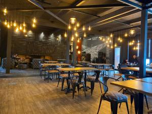 a restaurant with wooden tables and chairs and chandeliers at Apartment #513 in Gudauri Loft Hotel in Gudauri