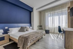 特尔尼Asso Residence Centro的卧室里有一张大床，墙壁是蓝色的