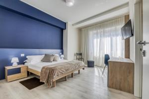 a bedroom with a large bed and a blue wall at Asso Residence Centro in Terni