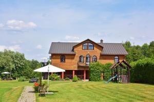 a wooden house with a playground in the yard at Bražuolėje Pas Juozą- ramiam poilsiui in Trakai