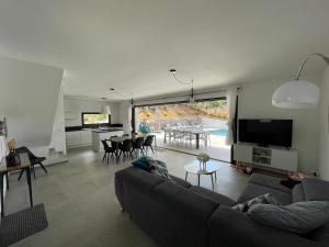 Una sala de estar con un sofá y una mesa con sillas. en Villa Mamago, en Cirendinu