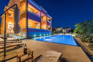une maison avec une piscine la nuit dans l'établissement Villa Marko, à Sveti Filip i Jakov