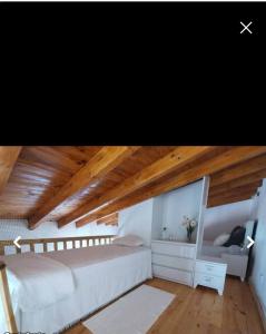 a bedroom with a white bed and a wooden ceiling at Casinhas Proença - Family in Aljezur