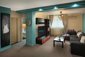 a living room with a couch and a flat screen tv at Piata Unirii Central Apartments in Iaşi