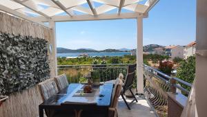 a patio with a table and a view of the ocean at Apartmani Villa Lilliana in Tribunj