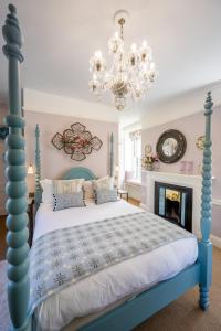 a bedroom with a blue bed and a chandelier at The Assembly House in Norwich