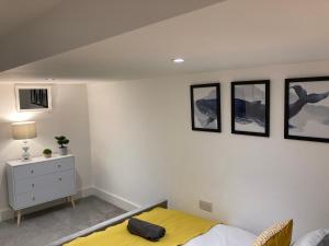 sypialnia z łóżkiem i 3 zdjęciami na ścianie w obiekcie THE GARDEN - LONG STAY OFFER - Priv GARDEN w mieście Strood