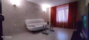 ニジニ・ノヴゴロドにあるУютные апартаменты на Родионоваの白い椅子と窓が備わる客室です。