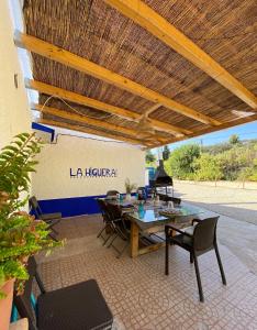 a patio with a table and chairs under a wooden roof at Casa Rural La Higuera in Ruidera