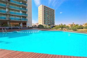 a large blue swimming pool in front of a building at El Remanso III in La Manga del Mar Menor