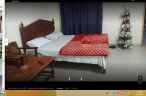a bedroom with a bed with a red blanket on it at Grace Hotel in Gobindpur
