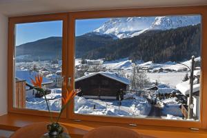 a window with a view of a snow covered mountain at Design Residence Del Passo in Padola