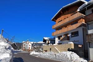 a building in the snow next to a street at Design Residence Del Passo in Padola