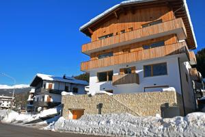 a building with snow on the ground in front of it at Design Residence Del Passo in Padola