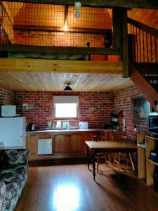 a kitchen with a table and a brick wall at Grampians Historic Tobacco Kiln in Moutajup