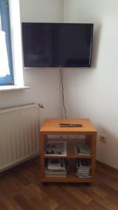 a table with a television on top of a wall at Ferienwohnung Schneider in Marburg an der Lahn