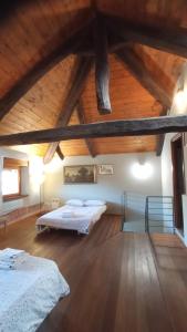 1 Schlafzimmer mit 2 Betten und Holzdecke in der Unterkunft CasaProsit city center with car parking in Asti