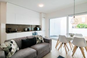 - un salon avec un canapé, une table et des chaises dans l'établissement Brissago 3 by Quokka 360 - romantic one-bedroom flat with large terrace, à Brissago