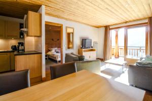 een keuken en een woonkamer met een tafel en een woonkamer bij Vue panoramique sur les montagnes plein Sud - T2 Skis aux pieds, Piscine, Jacuzzi in Flaine