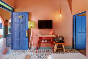 um quarto com uma porta azul e uma mesa em Por Aqui Stay & Dine em Timuran