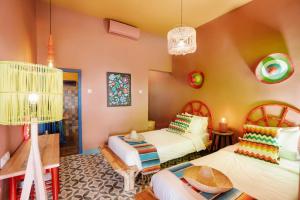 um quarto com 2 camas e uma mesa em Por Aqui Stay & Dine em Timuran