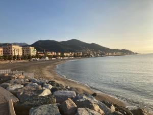 a beach with rocks and buildings and the water at Trilocale San Nazario in Varazze