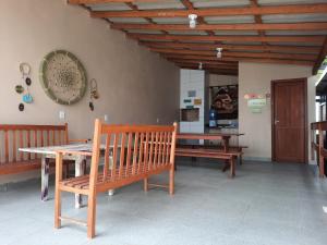 a dining room with two benches and a table at Recanto dos Guimarães in Palhoça