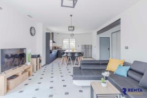 sala de estar con sofá y cocina en La Villa Rosa Wifi Jardin Barbecue, en Béziers