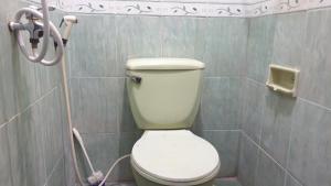 a bathroom with a white toilet in a stall at Castle Residence Syariah RedPartner in Siwalapkerto