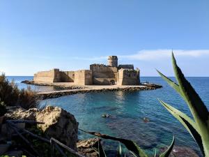 a castle on an island in the ocean at Ostello Bella Calabria in Torre Ritani