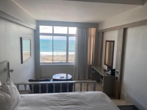 a bedroom with a bed and a view of the ocean at Kennaway Hotel in East London