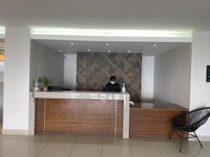 a person sitting at a reception desk in a lobby at Kennaway Hotel in East London