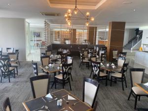 a dining room with tables and chairs in a restaurant at Kennaway Hotel in East London