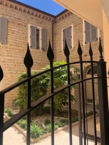 una recinzione nera di fronte a un edificio di mattoni di Casa Celin:in centro storico ad un passo dal mare a Pesaro