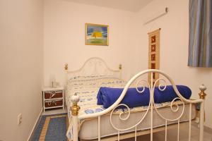a bedroom with a white bed with a blue blanket at Apartment Bebek & Grosic - Gorica in Baška