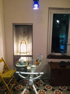 een kamer met een glazen tafel en een stoel bij La maison des secrets in Bédoin