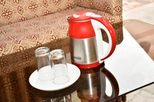 a coffee maker and two glasses on a table at HOTEL HIMALYAN PARADISE in McLeod Ganj