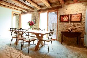 a table and chairs in a room with a stone wall at Casa Rural Harri Etxea in Iracheta