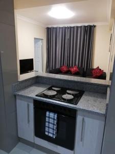 a kitchen with a stove and a counter top at Afsaal flats in Amanzimtoti